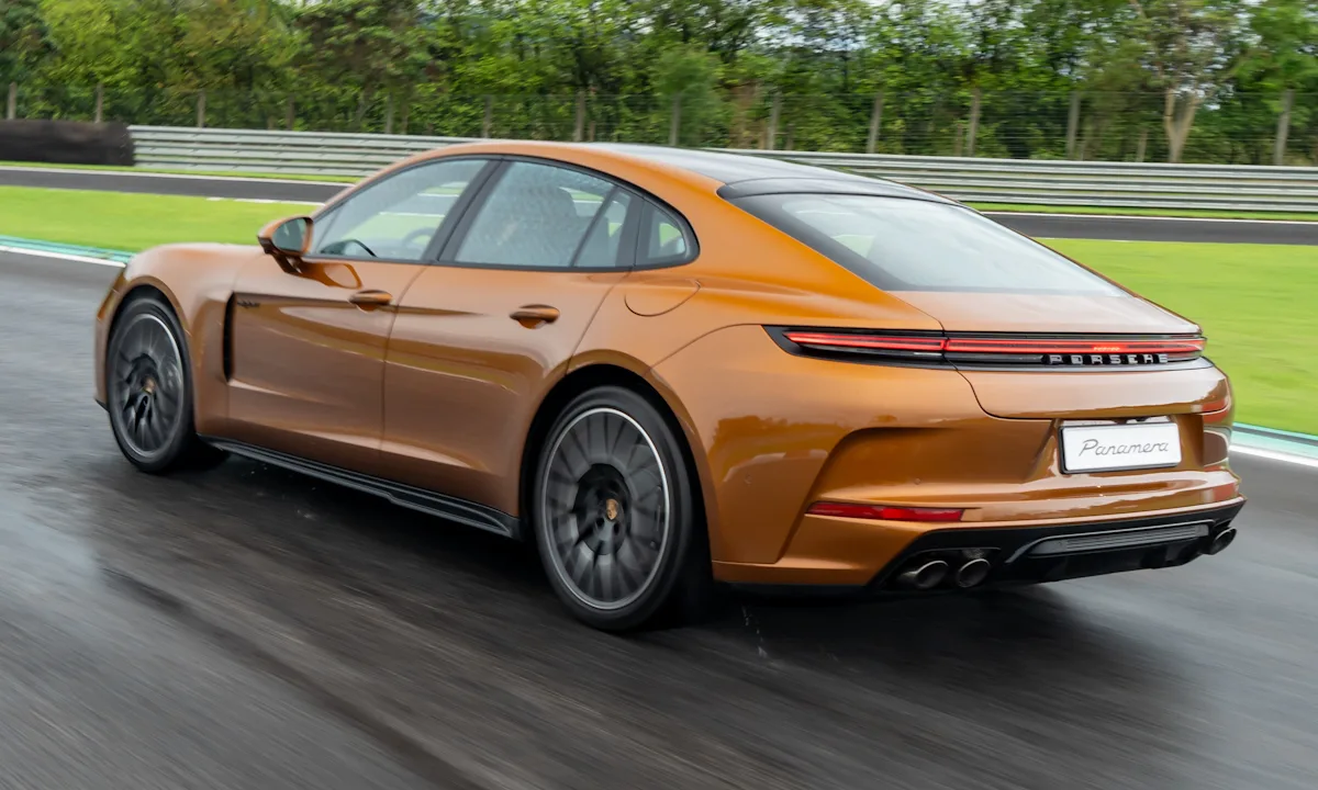 Porsche Panamera 2025 dourado de traseira correndo em uma pista molhada