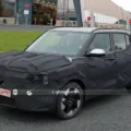 Novo SUV elétrico EV2 da Kia fazendo teste na rua, camuflado de preto e visto de frente