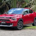 Citroën Basalt Shine vermelho com teto preto parado em frente a uma floresta