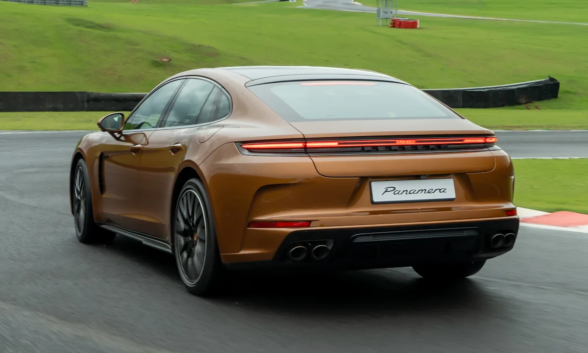 Porsche Panamera 2025 dourado de traseira correndo em uma pista molhada