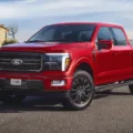 Ford F-150 vermelha parada de frente no asfalto