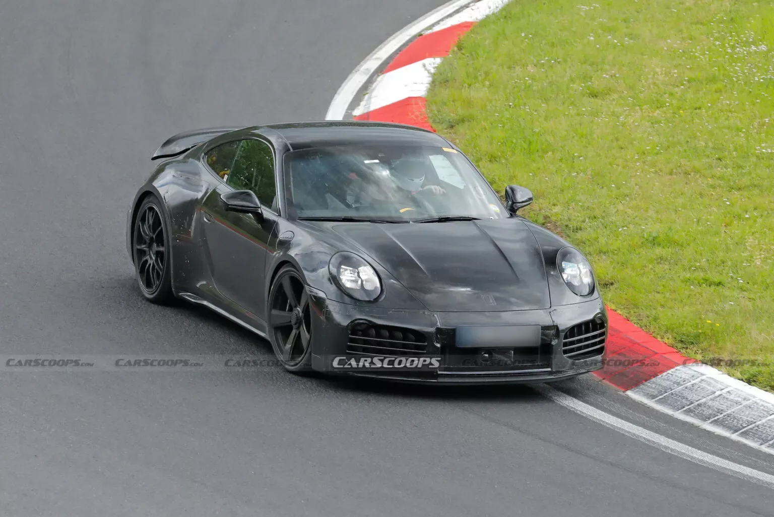 Porsche 911 Turbo Hybrid preto andando na pista