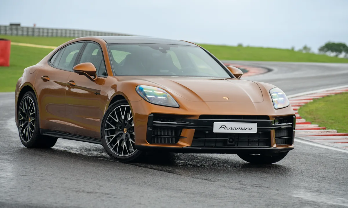 Porsche Panamera 2025 dourado de frente parado em uma pista molhada