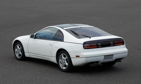 Nissan 300ZX branco parado no meio do asfalto em vista traseira de cima