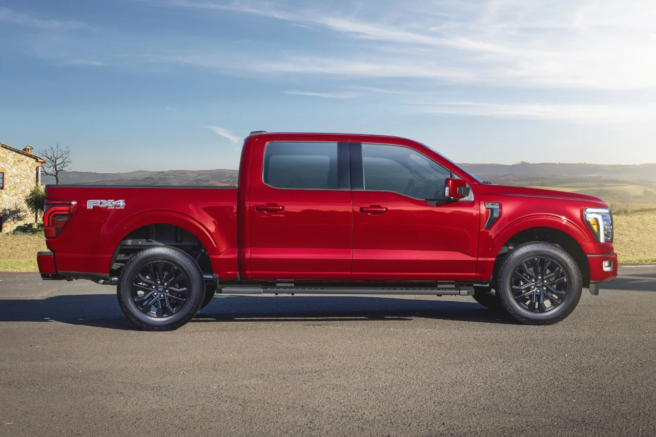 Ford F-150 Lariat Black 2025 vermelha estacionada de lateral no asfalto com o céu azul