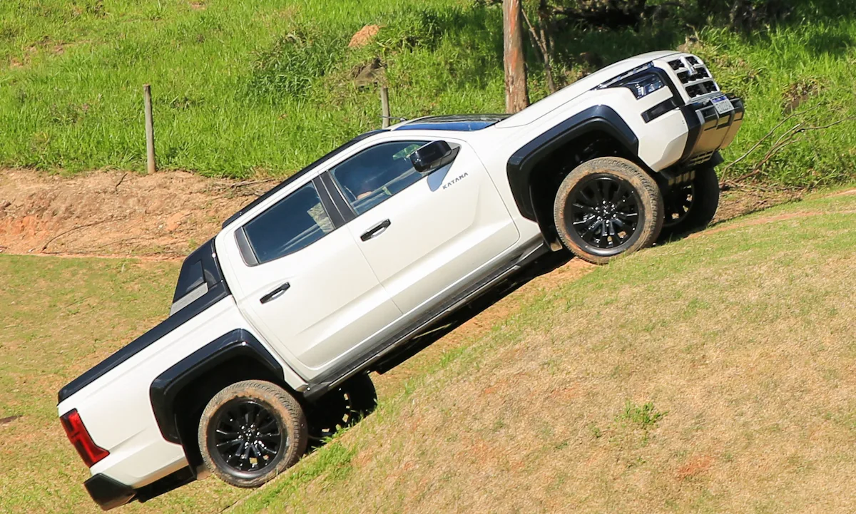 Mitsubishi Triton Katana branca de traseira no meio das pedras