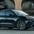 Novo Porsche Macan elétrico Turbo preto, visto de frente e portões ao fundo