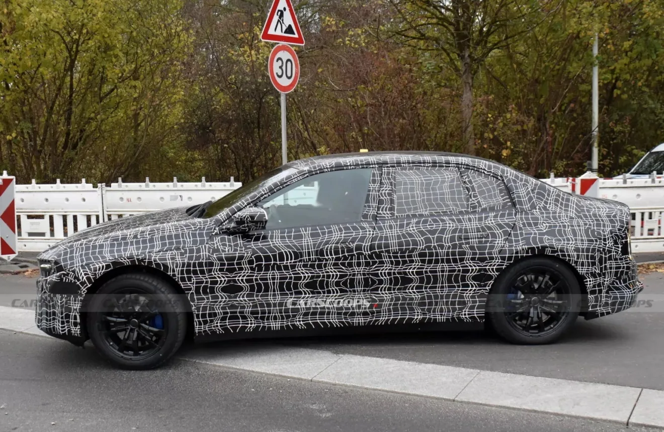 Protótipo do BMW i 3 sedã com pintura escurecida, visto de lado, com placas e árvores ao lado