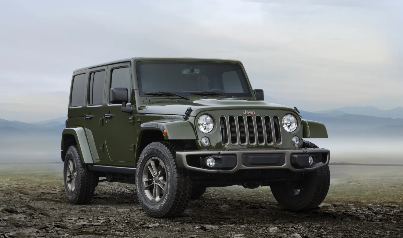 Jeep Wrangler Unlimited 75th Anniversary verde de frente com detalhes em bronze no fora de estrada