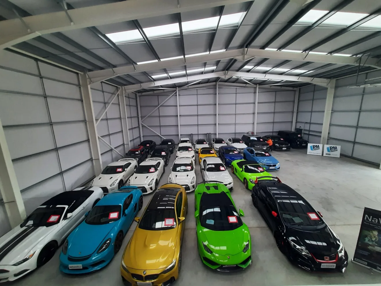 Carros esportivos e recuperados estacionados em um galpão - Piso de garagem