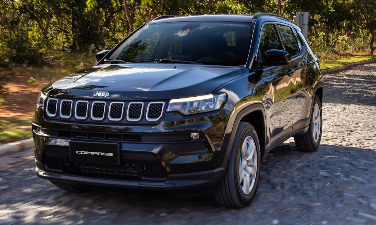 Jeep Compass Sport preto de frente andando na estrada