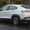 Fiat Fastback Audace Hybrid branco parado de traseira na chuva