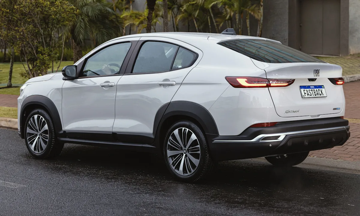 Fiat Fastback Audace Hybrid branco parado de traseira na chuva