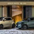 Fiat 500e Giorgio Armani em duas cores, vistos de frente e com o hotel Armani Milano de fundo