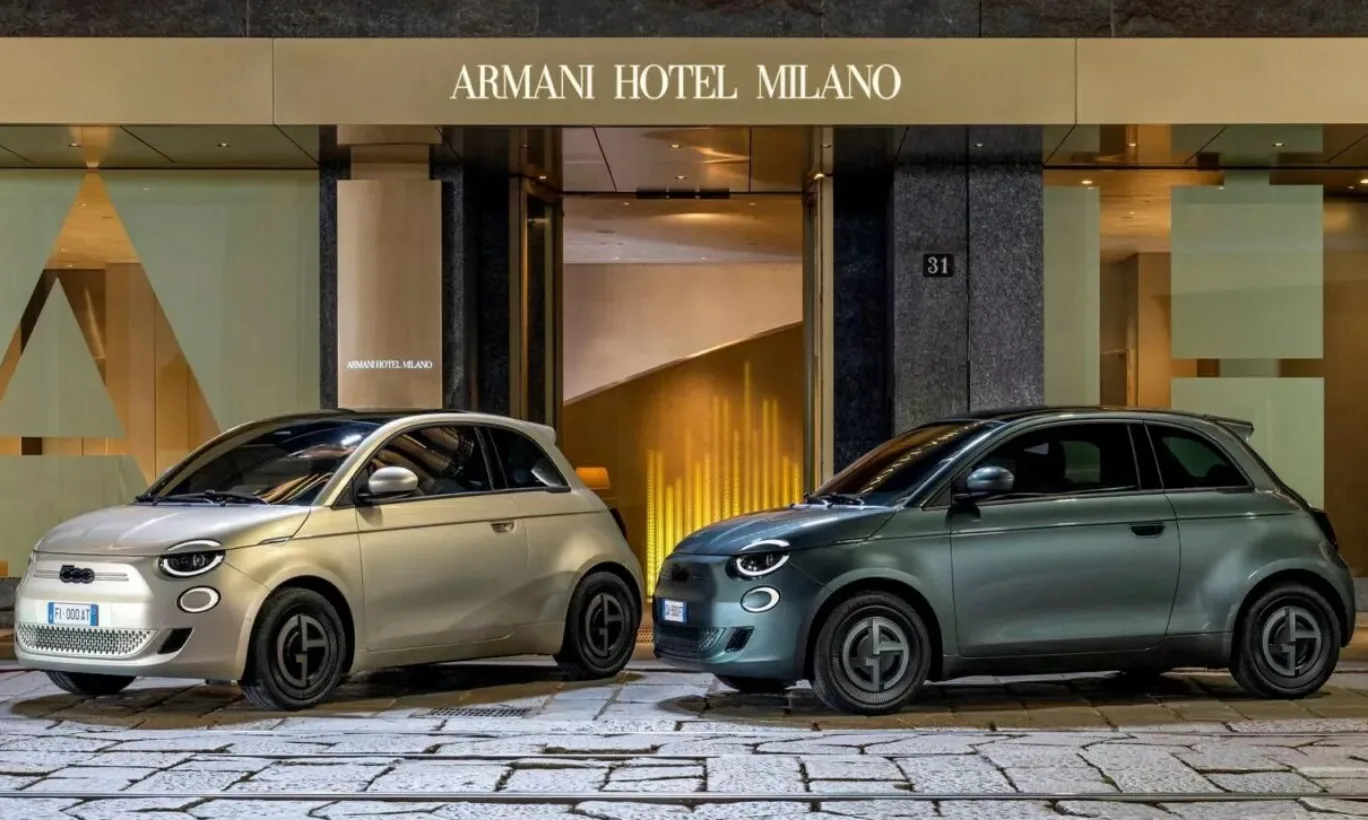 Fiat 500e Giorgio Armani em duas cores, vistos de frente e com o hotel Armani Milano de fundo