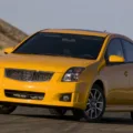 Nissan Sentra SE-R Spec V amarelo de frente no asfalto com montanhas ao fundo