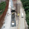 Trecho da BR-163 em obras de pavimentação em SC, visto de cima e com caminhões em trabalho