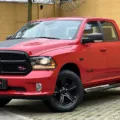 Ram Classic R/T estacionada de frente no asfalto com muro amarelo e palmeira ao fundo