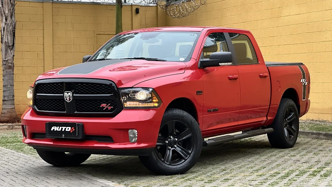 Ram Classic R/T estacionada de frente no asfalto com muro amarelo e palmeira ao fundo