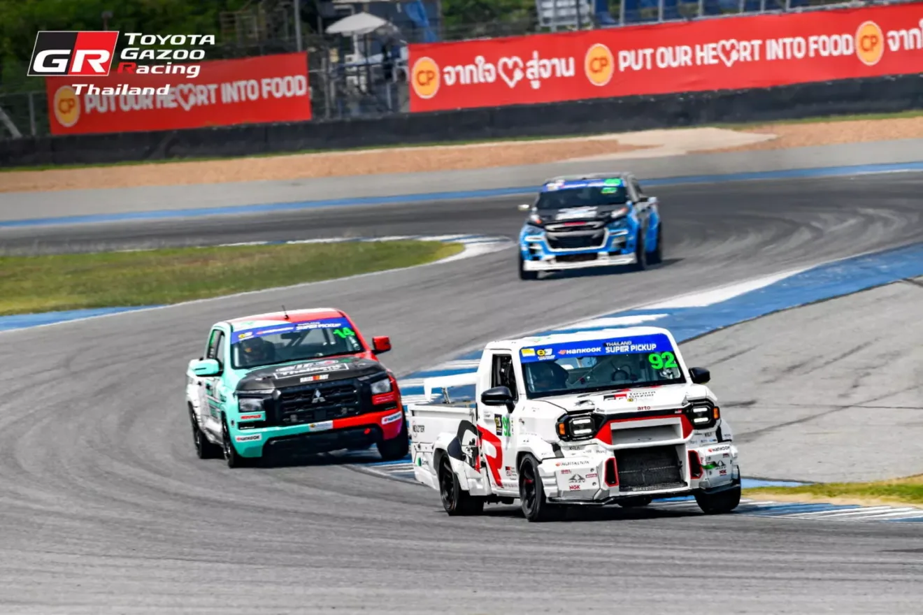 Caminhonete Hilux Champ branca em versão de corrida andando disputando a curva com a Mitsubishi L200 Triton