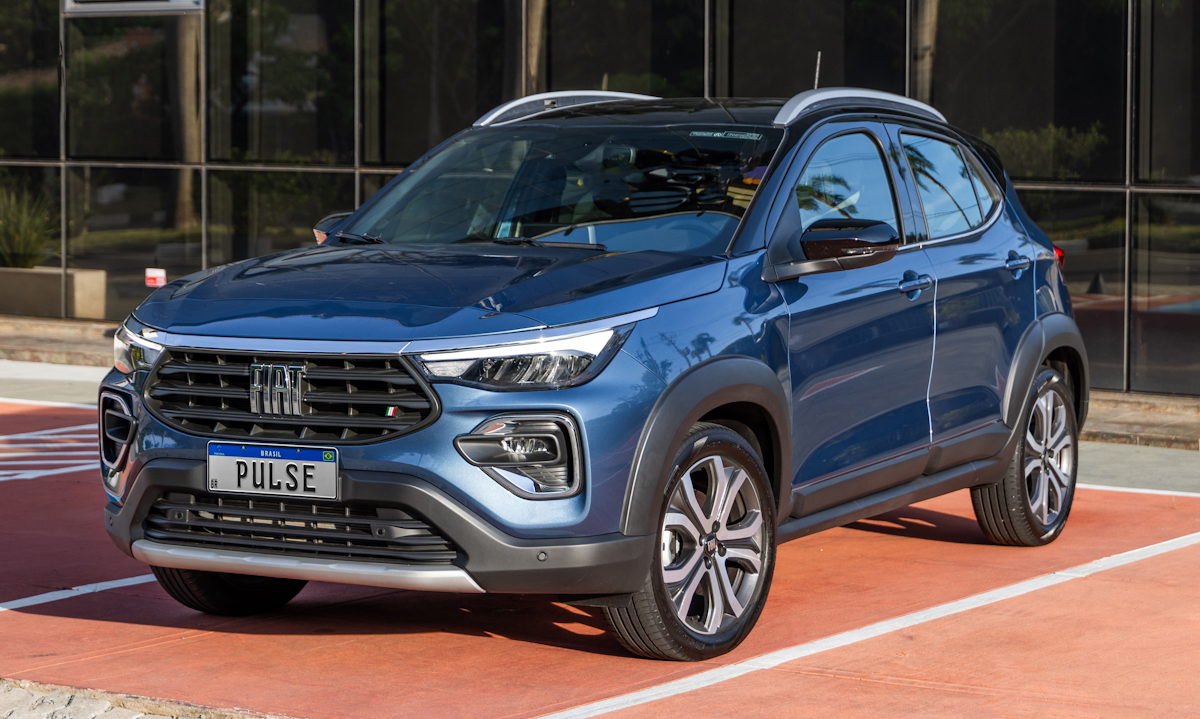 Fiat Pulse Impetus Hybrid azul Amalfi com teto preto parado de frente em um estacionamento com piso vermelho