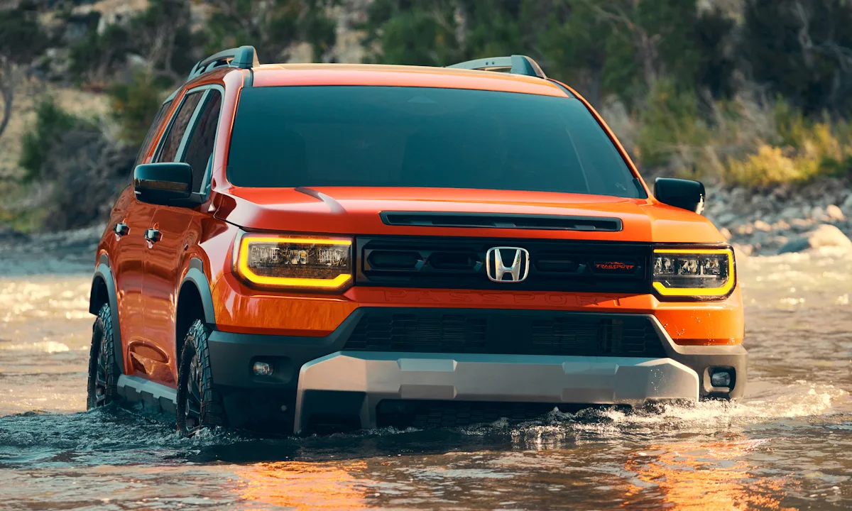 Honda Passport laranja de frente passando por um rio