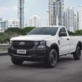 Ford Ranger com duas portas andando na cidade sobre o asfalto com prédios ao fundo