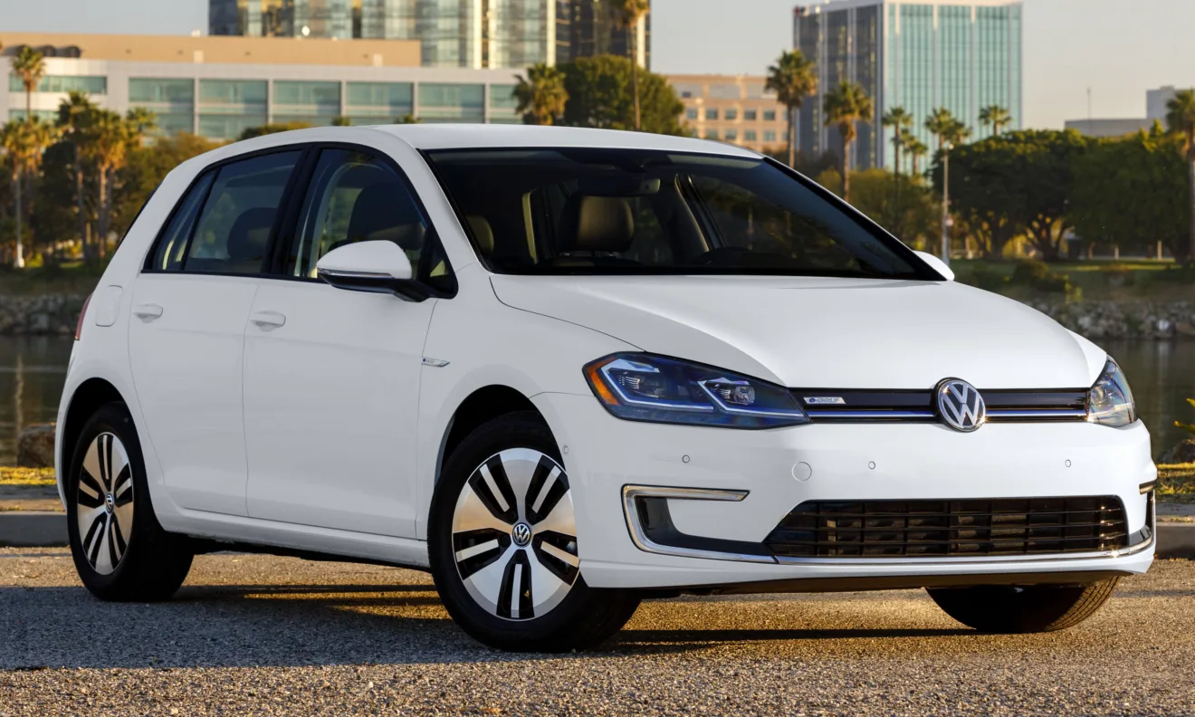 Volkswagen e-Golf branco, visto de frente e com casa ao fundo