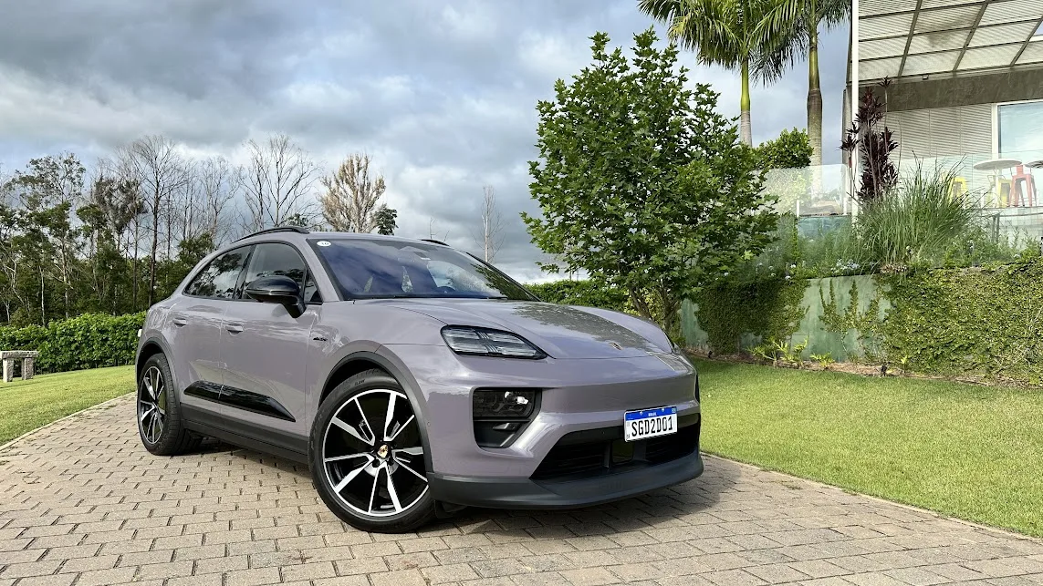 Porsche Macan 4 roxo parado de frente com árvore e casa ao fundo