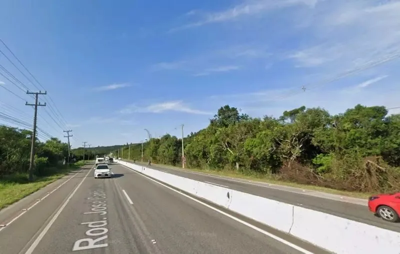 Rodovia SC-401 com carros passando, céu aberto e vista lateralmente