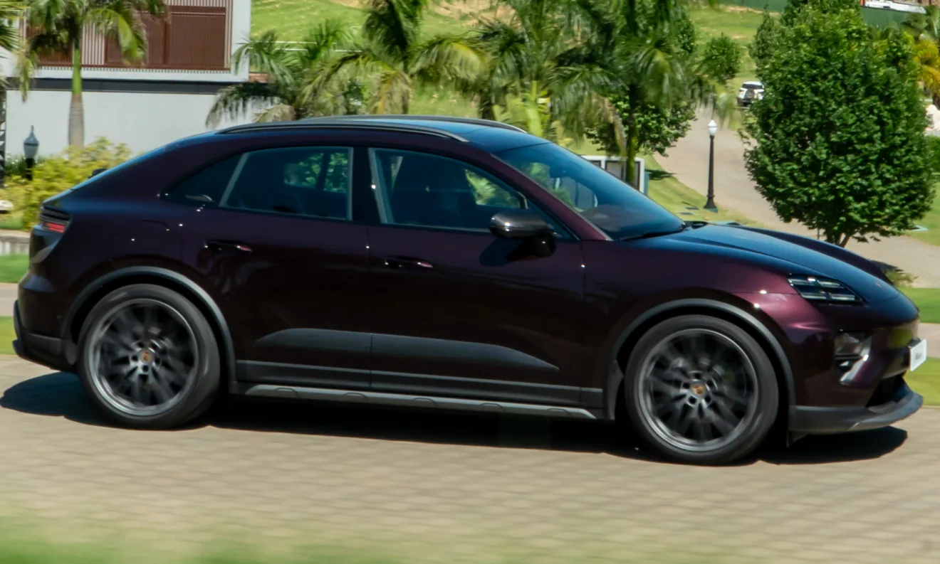 Novo Porsche Macan 4 elétrico amarronzado visto de lado, com árvores ao fundo