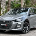 Peugeot 208 GT 2025 cinza parado de frente com árvores ao fundo