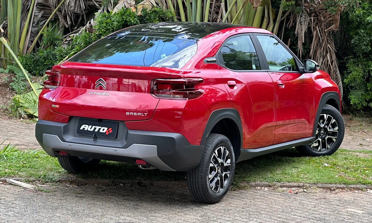 Citroën Basalt Shine vermelho com teto preto parado em frente a uma floresta