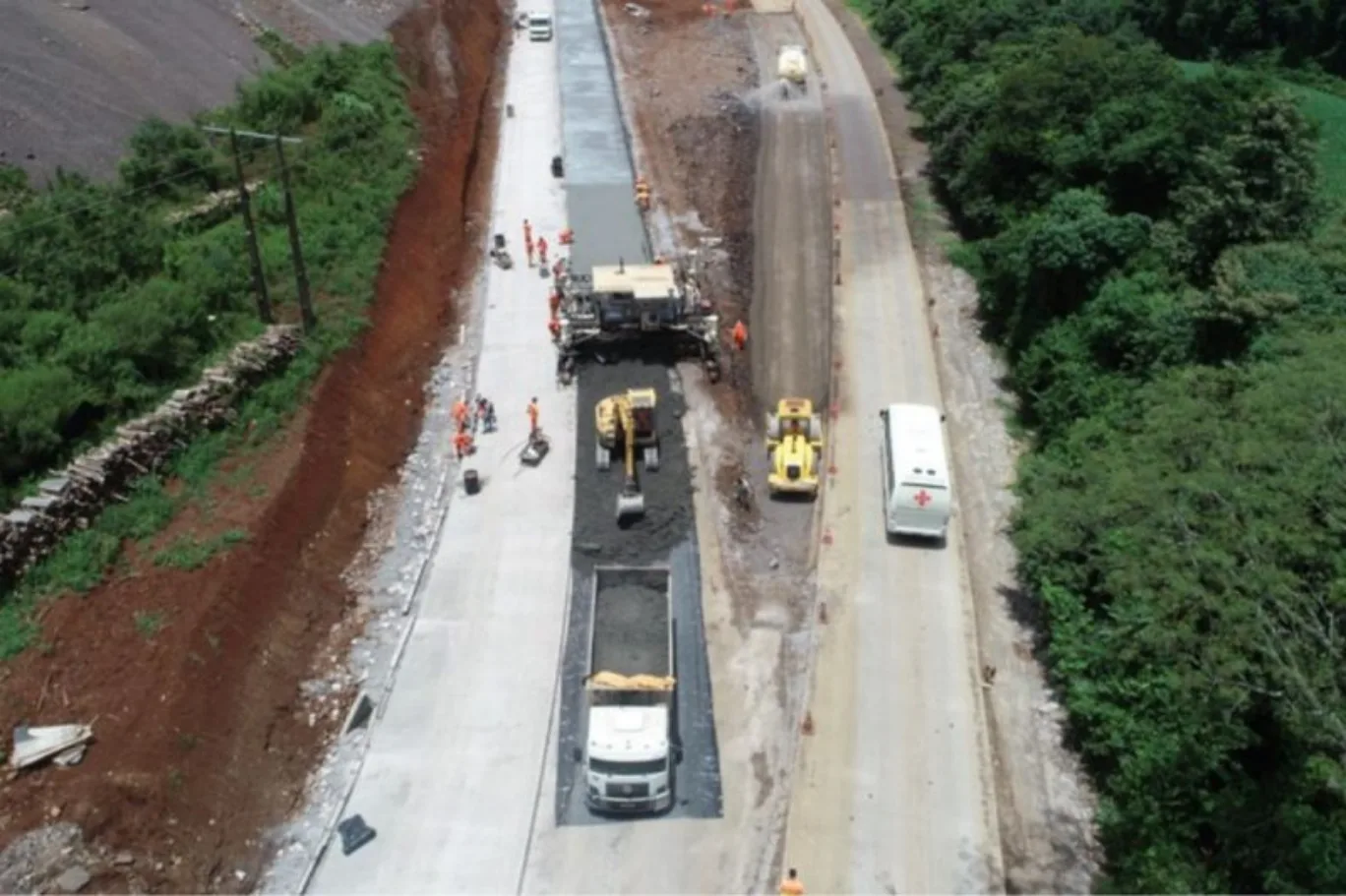 Trecho da BR-163 em obras de pavimentação em SC, visto de cima e com caminhões em trabalho