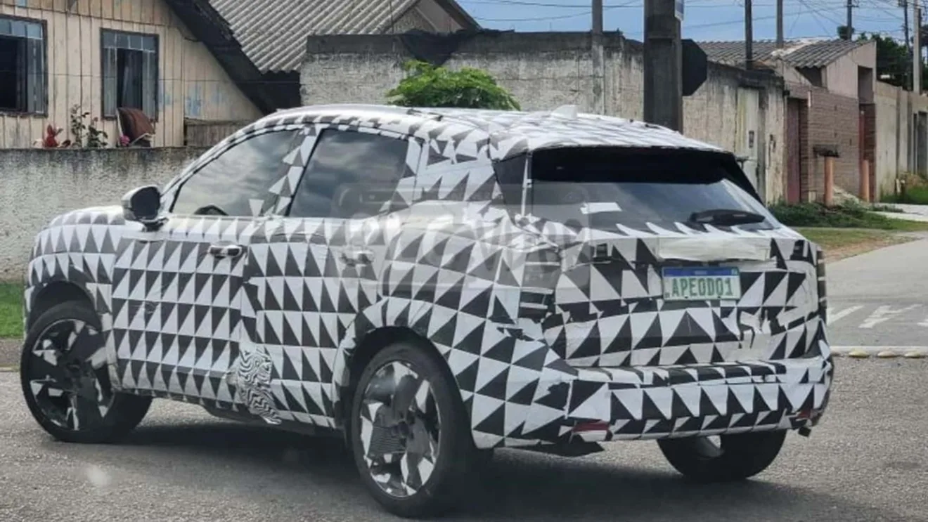 Novo Nissan Kicks camuflado de preto e branco, visto de trás e casas ao redor