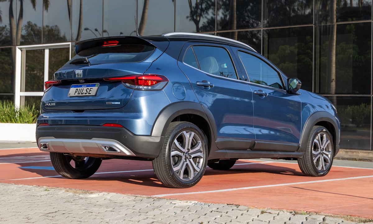 Fiat Pulse Impetus Hybrid azul Amalfi com teto preto parado de frente em um estacionamento com piso vermelho