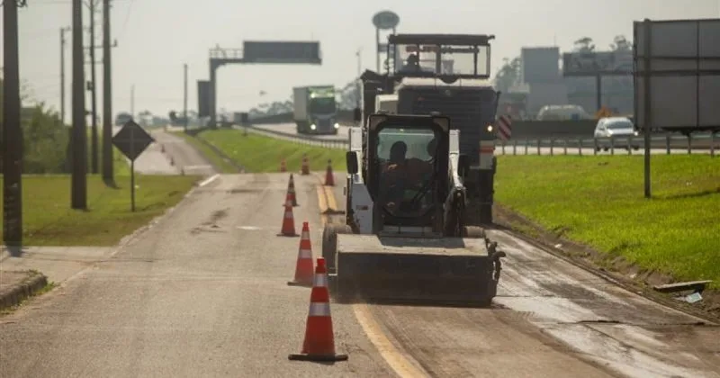 Maquinário de obras trabalhando na BR-101 com caminhão ao fundo