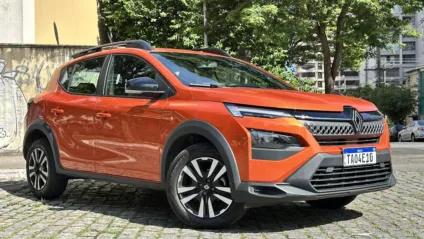 Renault Kardian Evolution MT laranja parado de frente com muro e árvore ao fundo