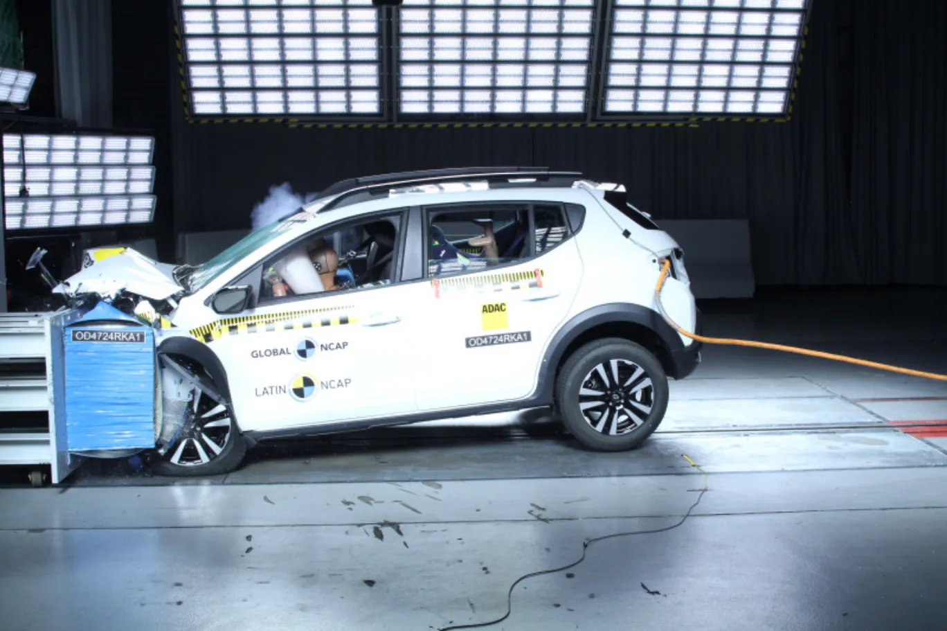 Renault Kardian branco, visto de lado e sofrendo impacto frontal