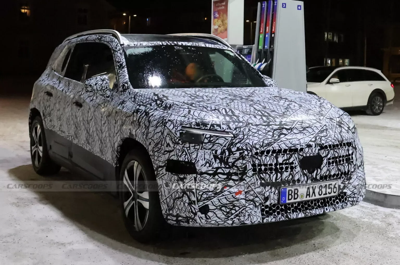 Novo Mercedes-Benz GLB flagrado em testes sob forte camuflagem parado em um posto de combustíveis