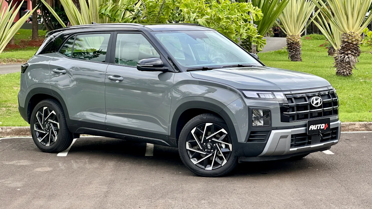 Hyundai Creta Ultimate cinza com teto preto estacionado mostrando a frente com um jardim ao fundo