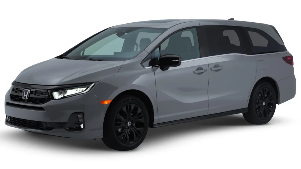 Honda Odyssey cinza com partes pretas, visto de frente, com faróis acesos e fundo branco