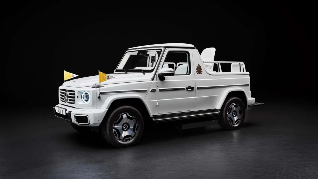 Mercedes-Benz Classe G elétrico branco como Papamóvel, com faróis acesos e bandeirinhas amarelas, visto de frente e sem teto