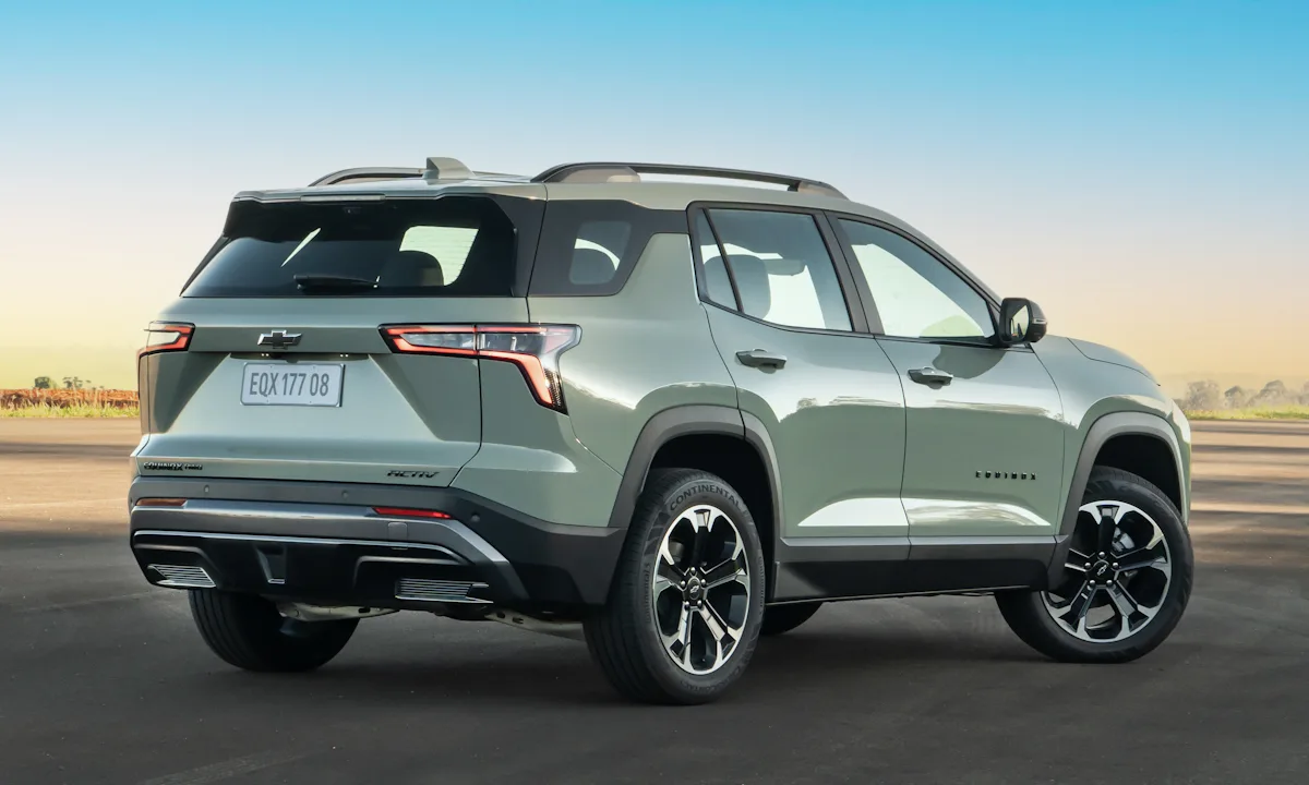 Chevrolet Equinox Activ 2025 verde parado de traseira em um por do sol