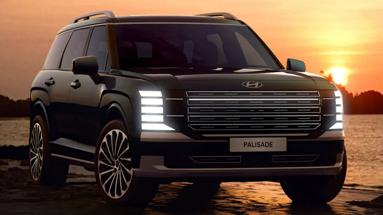 Novo Hyundai Palisade cinza escuro, visto de frente, com faróis acesos e fundo claro