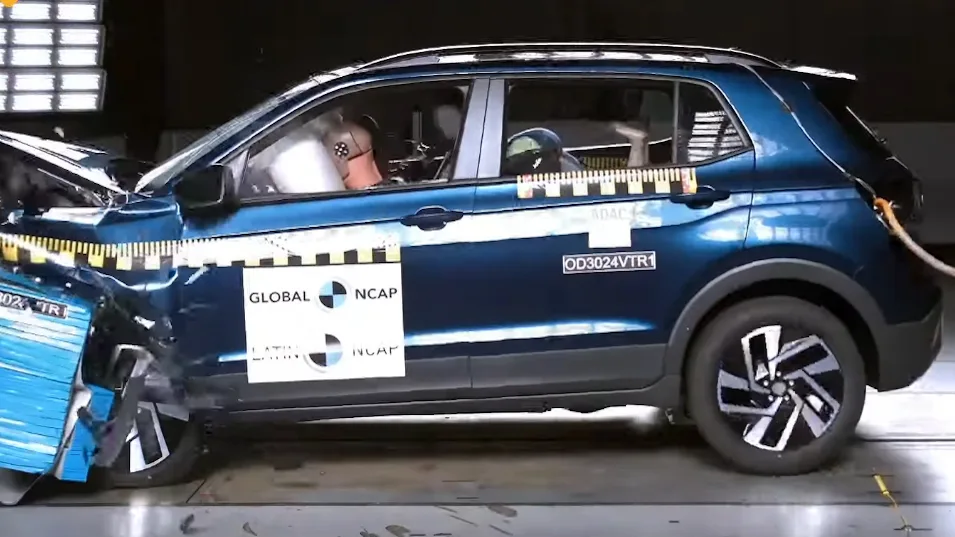 Volkswagen T-Cross azul, visto lateralmente, sofrendo impacto frontal e com airbags estourados