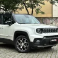 Jeep Renegade Sahara branco parado de frente com muro ao fundo