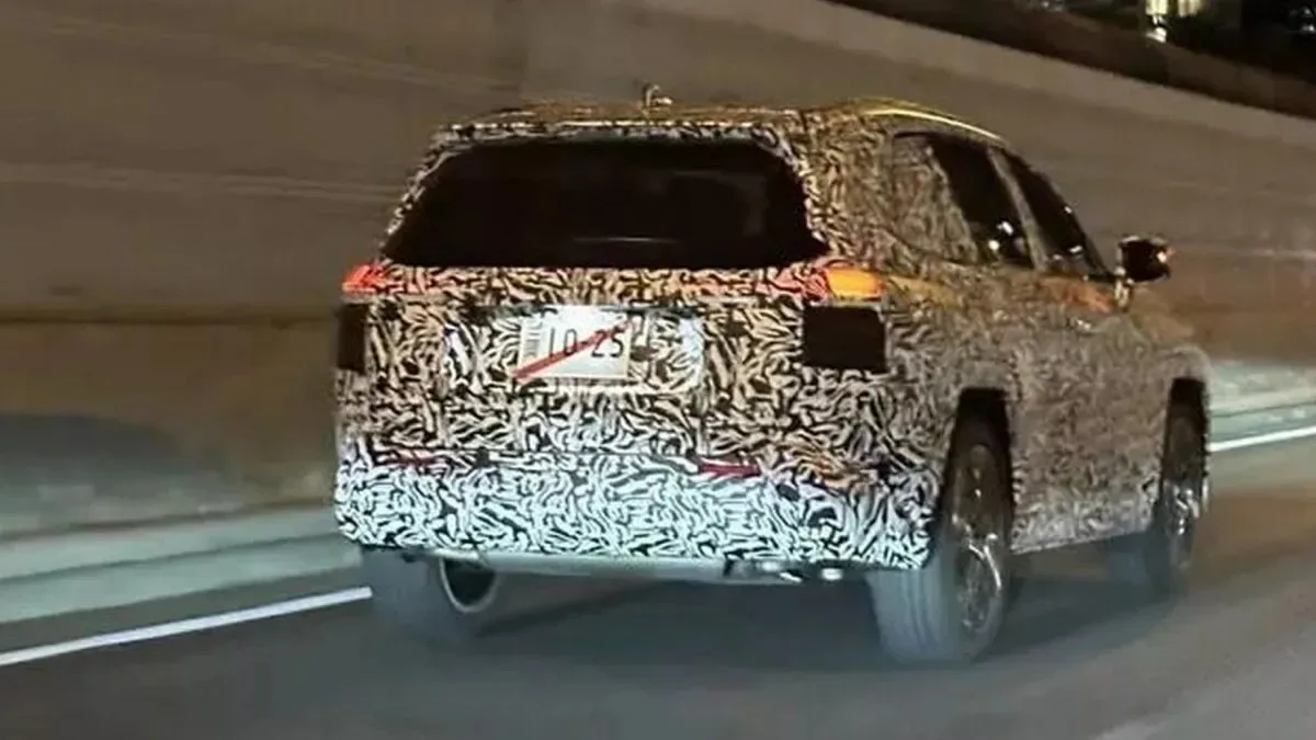 Novo Toyota RAV4 de traseira andando na estrada com as lanternas acesas