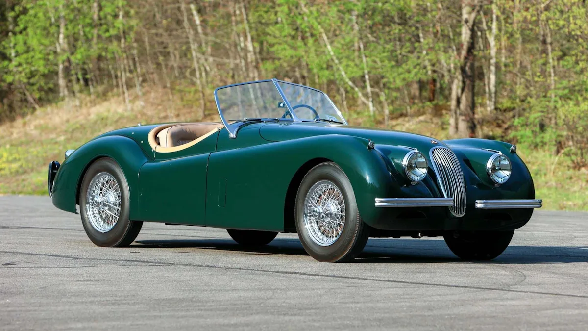 XK 120 é um dos carros mais icônicos da Jaguar. Roadster na cor verde com fundo de natureza.