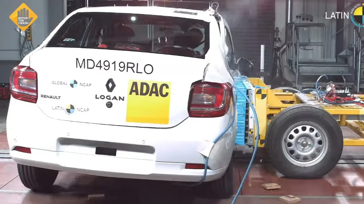 Renault Logan branco, sofrendo impacto lateral e visto de trás